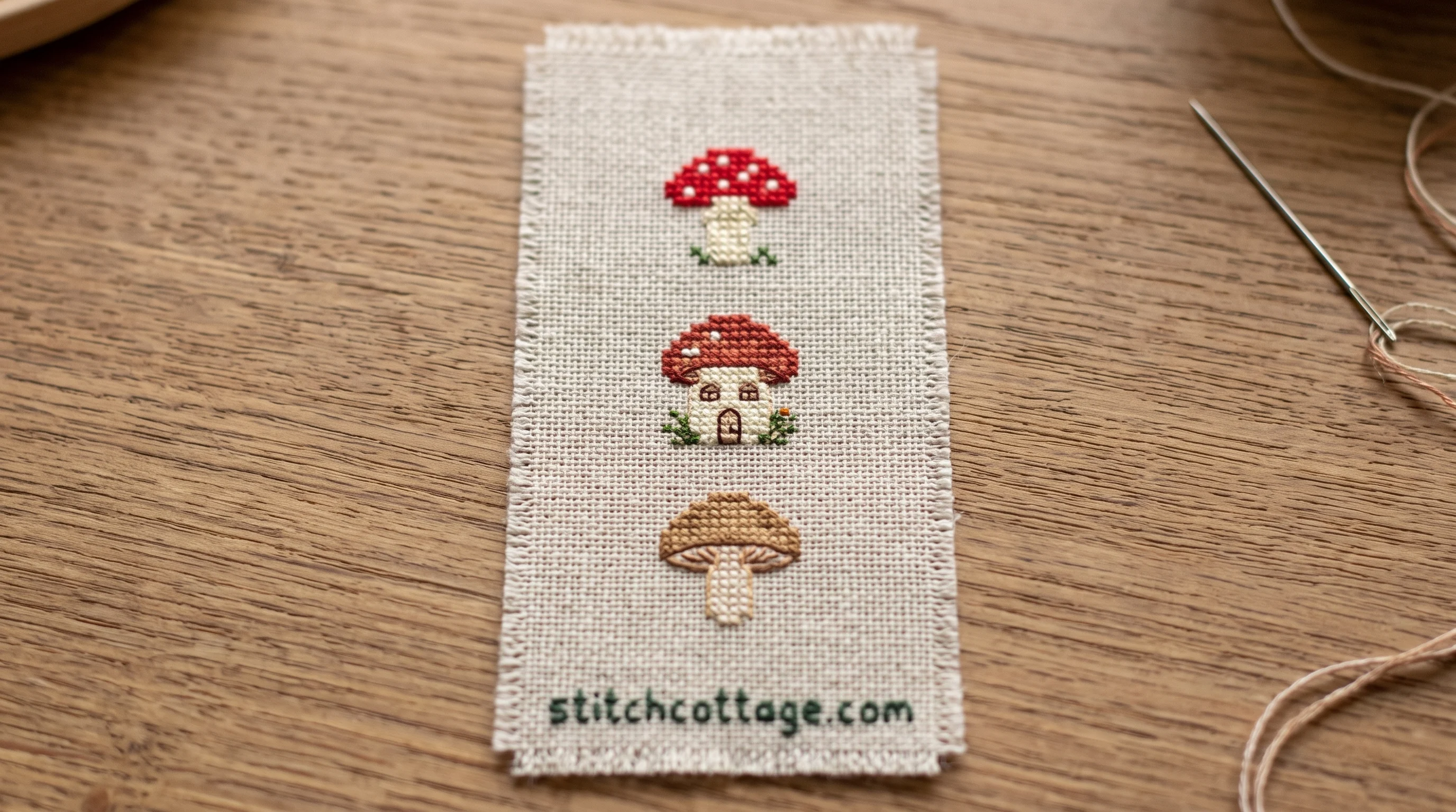 Tiny one-inch mushroom cross stitch finished as a bookmark corner