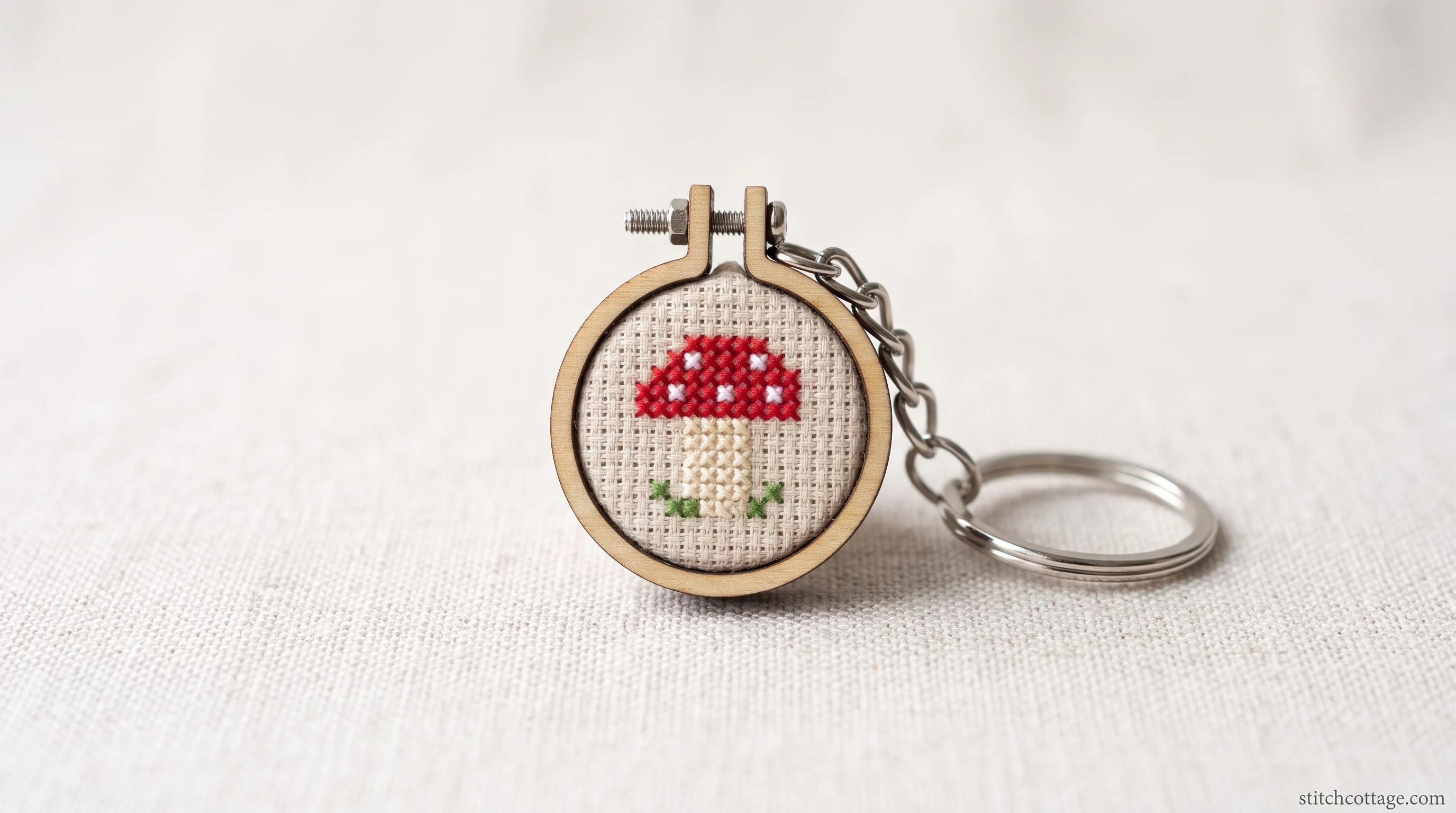 Tiny mushroom cross stitch motif finished as a keychain